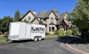 HomePro Idaho roof replacement work trailer parked at a large home before a new roof installation