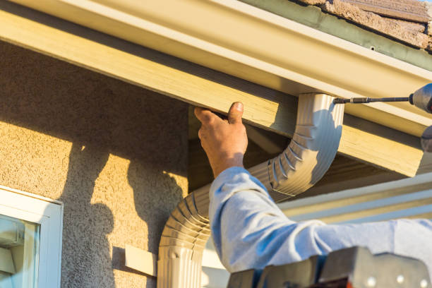 Working replacing gutters on a house