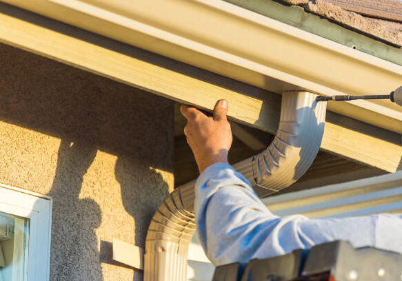 Working replacing gutters on a house