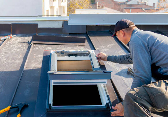 A man installing a skylight on a metal roof.